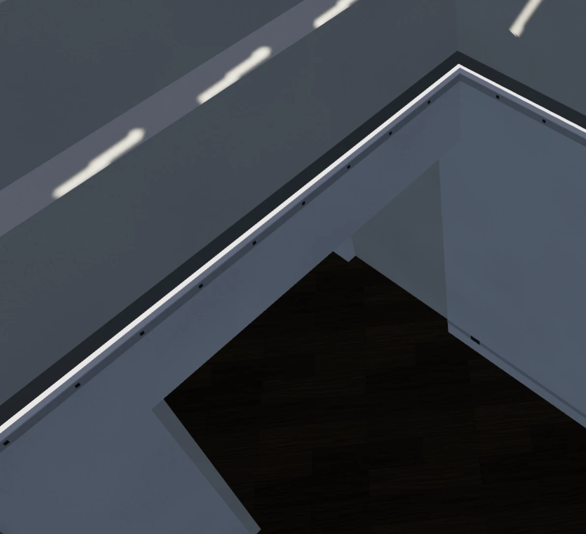 The top of a room's wall from above: the lining along the ceiling with its row of small sensor ports and the light strip